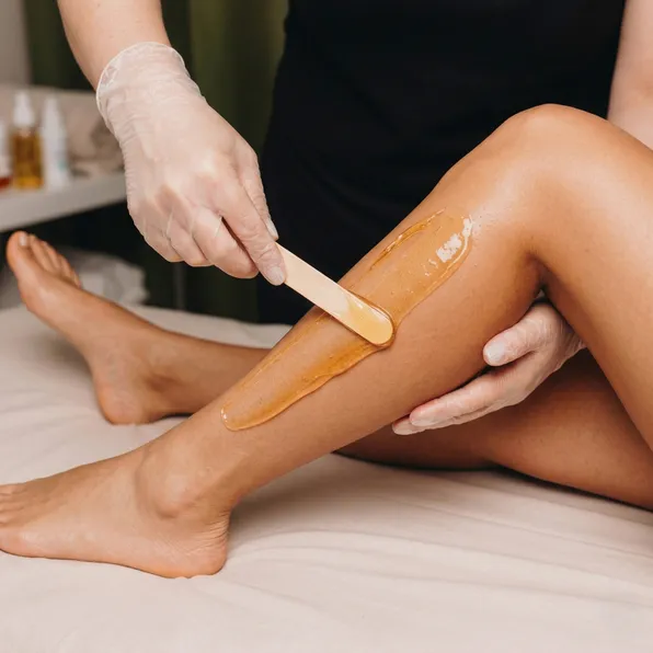 Waxing-Behandlung am Unterschenkel mit Zuckerpaste